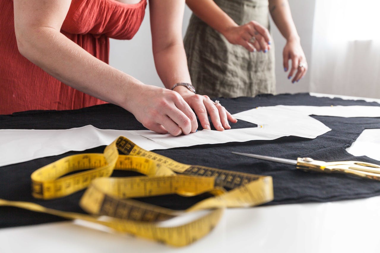 Mastering the First Impression: Your intriguing post title goes here Women working on sewing patterns with measuring tape and fabric.